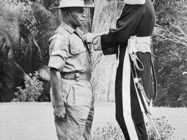 Corporal Charles Mene receives the Military Medal from Sir Douglas MacGillivray, British High Commissioner to Malaysia, 5 June 1957