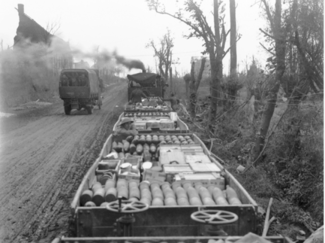 A trainload of ammunition passing along the metre gauge railway on the Menin Road, in the Ypres sector, 1917.