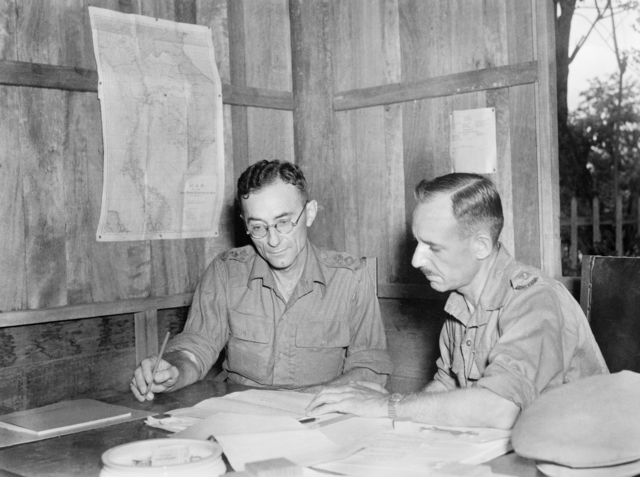 Lieutenant-Colonel (Lieut-Col) C. G. W. Anderson, VC, MC, 2/19th Australian Infantry Battalion (left) Commanding, Australian POWs in Thailand, conferring with Lieut-Col C. A. McEachern, Commanding Allied ex-pows in Thailand at the Pows Branch Headquarters Recovered Allied Pow and Internees Unit, at Vajirajudh College.