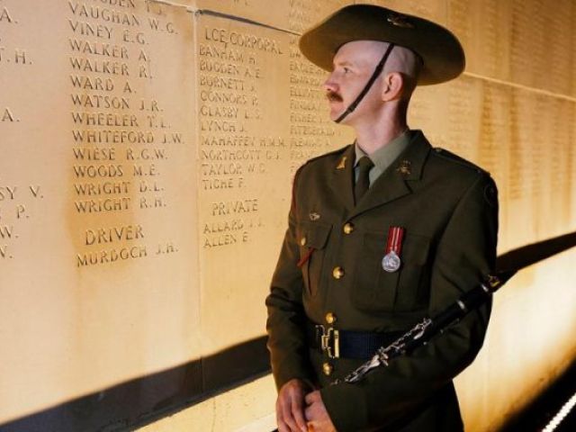 Musician Scott Collinson stands beside the name of his relative, Private Alexander Walker, prior the Anzac Day Dawn Service at the Australian National Memorial in Villers-Bretonneux, France. Photo: Sergeant Oliver Carter.