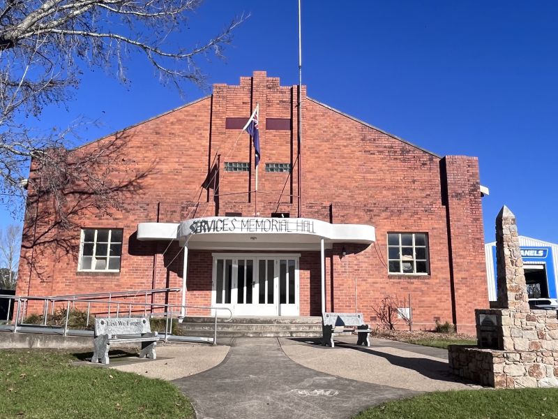 The War Memorial obelisk stands to the right of the Memorial Hall