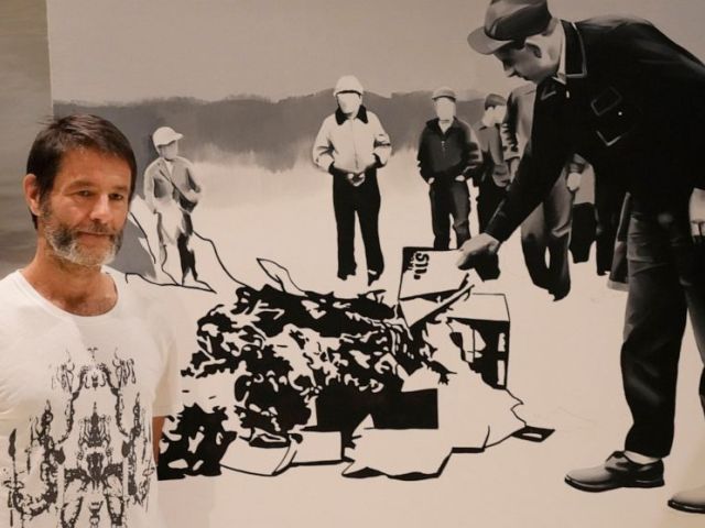 Polish artist Wilhelm Sasnal poses in front of one of his art works on display in a new exhibition at the POLIN Museum of the History of Polish Jews, in Warsaw, Poland, on Tuesday June 15, 2021. AP Photo/Czarek Sokolowski
