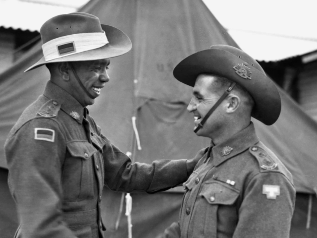 Lieutenants Reginald Saunders and Tom Derrick VC congratulate each other on receiving their commissions in November 1944. The two men shared a tent during their officer training. CREDIT: AUSTRALIAN WAR MEMORIAL