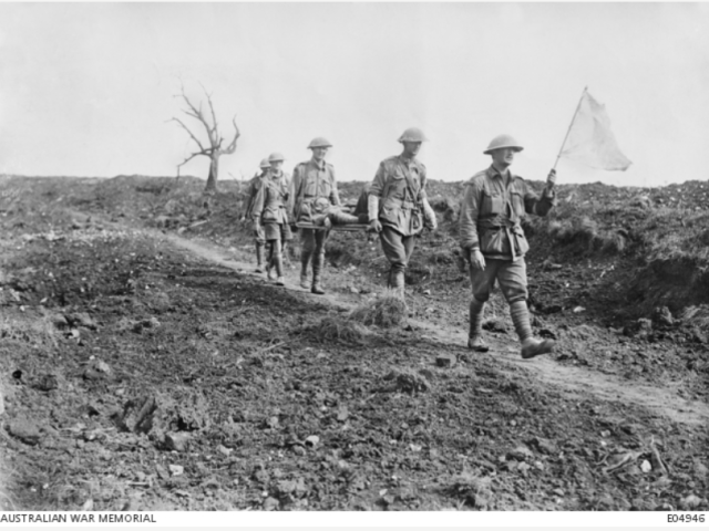 Australian stretcher bearers coming in under a white flag, passing the old cemetery of Pozieres, having come from the line near Mouquet Farm. August 1916