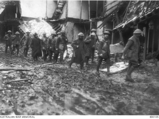 A working party of the 40th Battalion returning to their billets through the ruins of Houplines near Armentieres, after a day's work in the frozen trenches during December 1916.