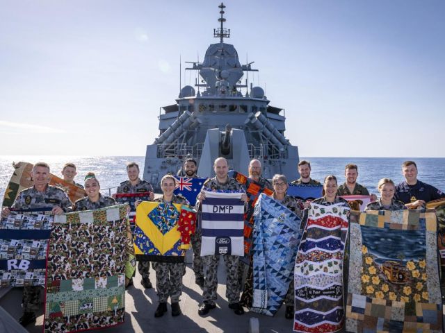 HMAS Anzac crew deployed on Indo-Pacific Endeavour 2021 show the personalised quilts and laundry bags made for them by volunteers from Aussie Hero Quilts. Photo: Leading Seaman Leo Baumgartner
