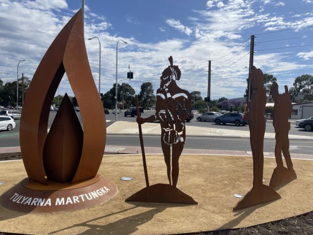 The artwork features a Karuna warrior standing alongside figures representing World War I and II soldiers. Image: South Australian government.