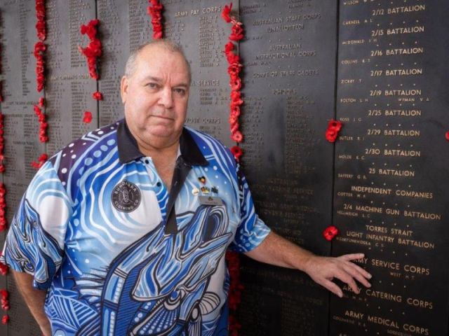 Australian War Memorial Indigenous Liaison Officer Michael Bell places a poppy beside the name of Private Ngakyunkwokka on the Roll of Honour. AWM25.PR051