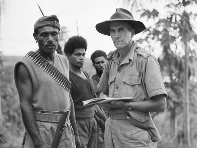 Captain T. Grahamslaw, Australia New Guinea Administrative Unit, with Sergeant-Major Katue of the Papuan Infantry Battalion and members of the Royal Papuan Constabulary, Waiwai, New Guinea, November 1942.