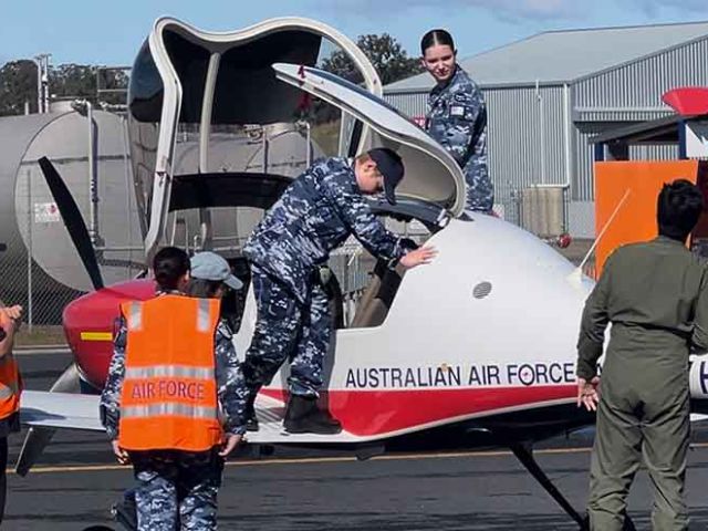Liam Higgins climbs into an AAf training plain for a pilot experience flight, Sis Higgins