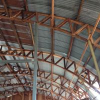 Parabolic arches holding the curved iron roof.