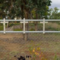 Metal crosses with names of enlistees on a fence
