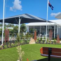 Memorial garden showing sculptures, flagpoles and seating 