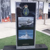 Royal Australian Navy badge, with two photographs of vessels, "Sacrifice" written at base of monument